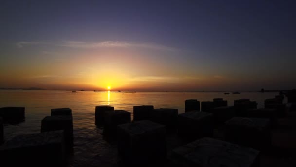 Solnedgång himmel till sjöss med silhuett av betong block förgrunden — Stockvideo