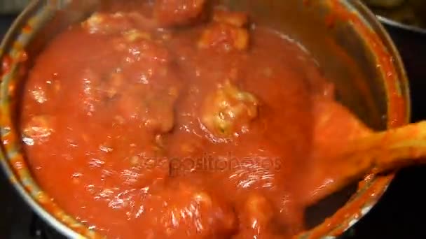 Albóndigas hirviendo en sopa de tomate con paleta de cocción de madera — Vídeos de Stock