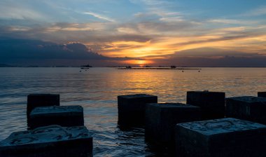 Deniz günbatımı gökyüzü ile plajda beton blok