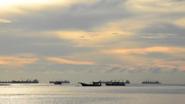 Човен причалює в морі з заходом сонця небо і хмари — стокове відео