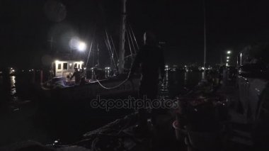 Gece zaman sabitlemek için balıkçı teknesi balık sepeti taşınan balıkçı