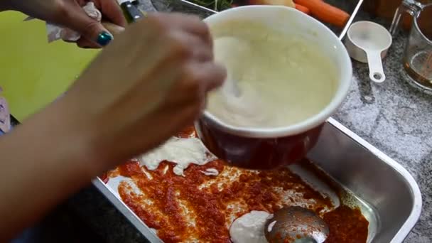 Woman put white sauce to tray for prepare baked pasta, Handheld shot — Stock Video
