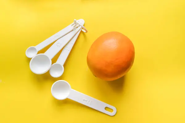 Plastic spoon on yellow background — Stock Photo, Image