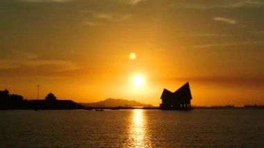 Günbatımı gökyüzü zaman atlamalı dock silueti ile denizde 