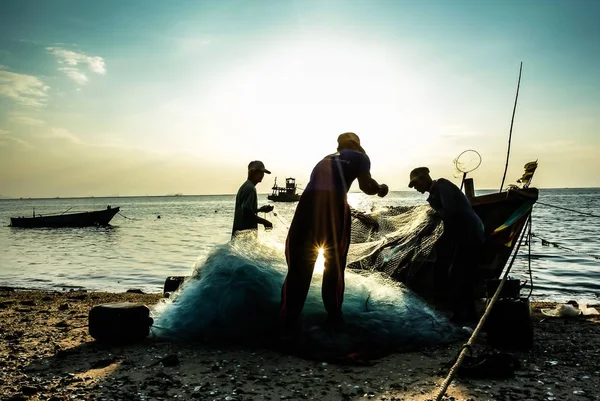 Gruppe von Fischern räumt Fisch aus dem Netz — Stockfoto