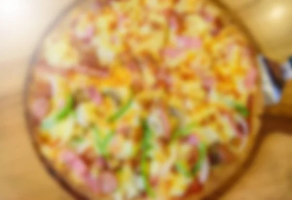 Niewyraźne tło, pyszne pizze na stole — Zdjęcie stockowe