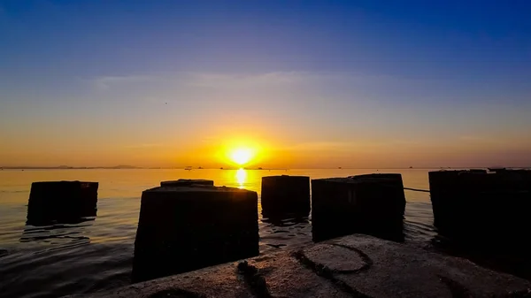 コンクリート シルエット前景と海で素敵な夕焼け空 — ストック写真