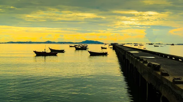 Nice céu pôr do sol com nuvens no mar com doca e barco primeiro plano — Fotografia de Stock