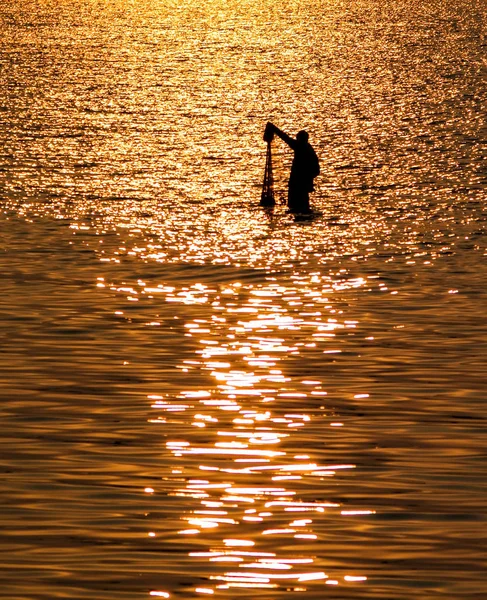 Pescador con red en el mar con reflejo de la luz del atardecer en el mar —  Fotos de Stock