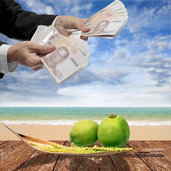 Businessman pay for coconut and spadix flower of coconut on deck — Stock Photo, Image