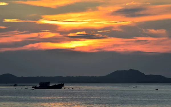 Günbatımının arka planında, denize demirleyen teknenin silueti. — Stok fotoğraf