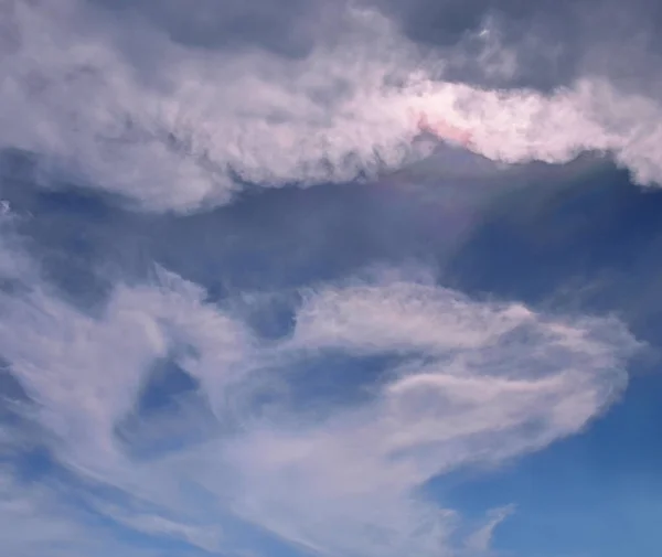 Mavi gökyüzünde bulutlar, bulutlarda gökkuşağı — Stok fotoğraf