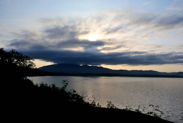 Göl kenarında bulutlarla dramatik bir sabah güneşi doğuyor. — Stok fotoğraf