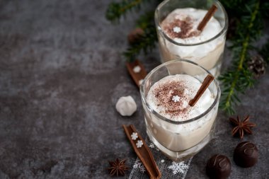 Cam bardakta yumurta likörü, narin bir köpük, baharatlar ve tarçın çubuğu.