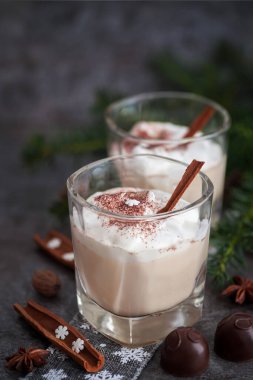 Cam bardakta yumurta likörü, narin bir köpük, baharatlar ve tarçın çubuğu.