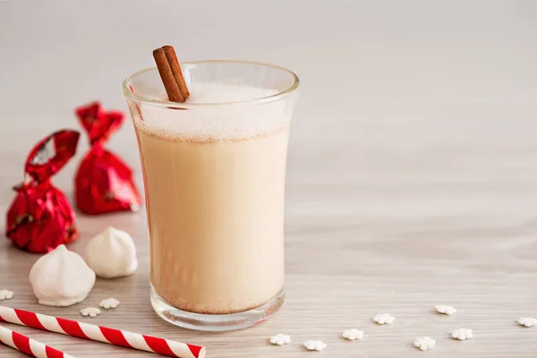 Eggnog in glass cups with a delicate foam, spices and a cinnamon stick — ストック写真