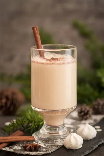 Eggnog in glass cups with a delicate foam, spices and a cinnamon stick — ストック写真