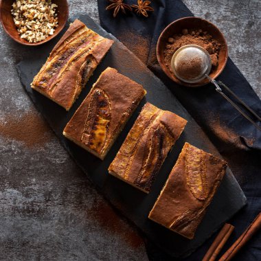 Arka planda baharatlı dilimlenmiş muzlu turta.