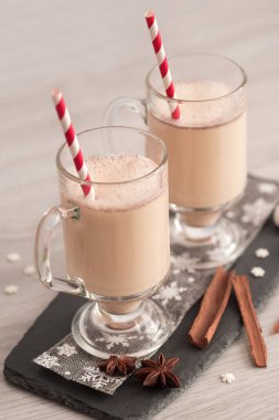 Cam bardakta yumurta likörü, narin bir köpük, baharatlar ve tarçın çubuğu.