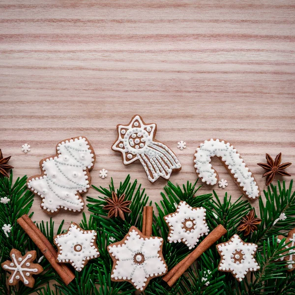 Frame with fir branches, cookies and Christmas decorations on a wooden background. Top view. — Stock Photo, Image