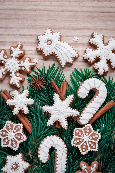 Frame with fir branches, cookies and Christmas decorations on a wooden background. Top view. — Stock Photo, Image