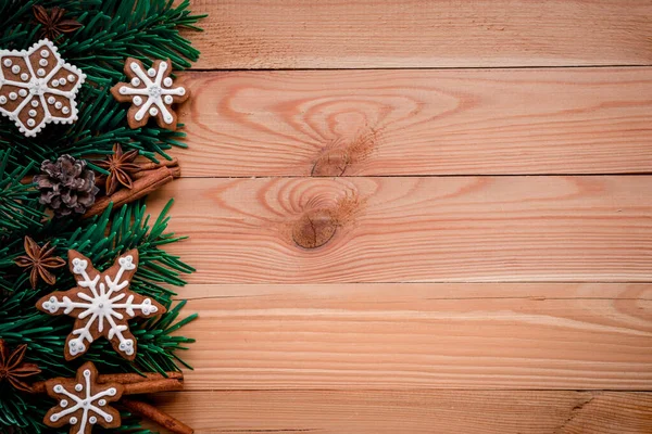 Cadre avec branches de sapin, biscuits et décorations de Noël sur un fond en bois. Vue du dessus . — Photo