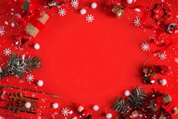 Borda de Natal de brinquedos, caixa de presente, fitas e flocos de neve em fundo vermelho — Fotografia de Stock
