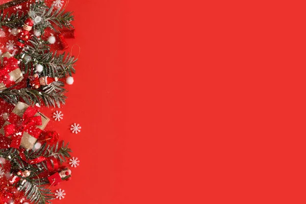 Borde navideño de juguetes, caja de regalo, cintas y copos de nieve sobre fondo rojo —  Fotos de Stock