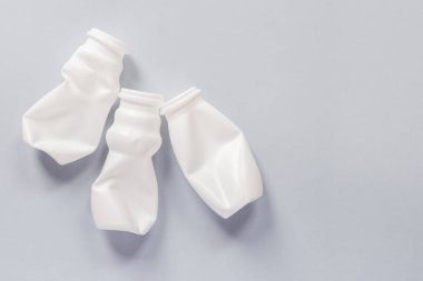 Gri arka planda yiyecek için kullanılan beyaz plastik ambalaj