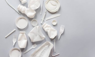 Gri arka planda yiyecek için kullanılan beyaz plastik ambalaj
