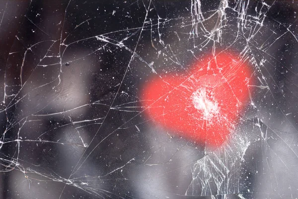 Teléfono móvil con grietas en el cristal y un patrón en forma de corazón en la parte superior —  Fotos de Stock