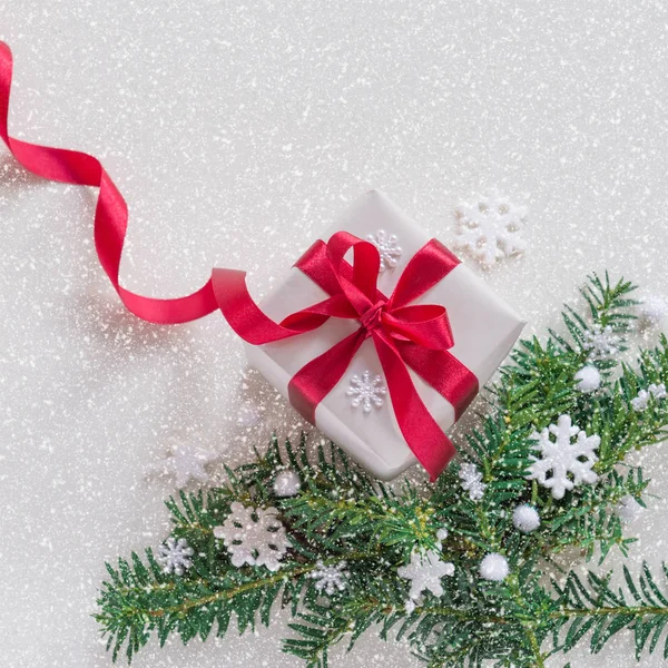 Regalos de Navidad con cintas rojas y ramas de pino sobre un fondo cubierto de nieve —  Fotos de Stock