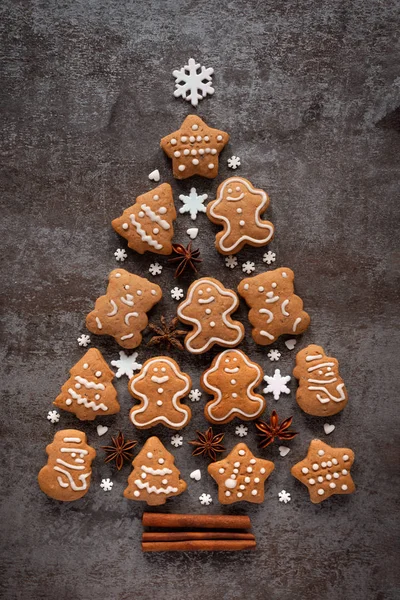 Pão de gengibre, estrelas de anis e paus de canela criam uma árvore de Natal em um fundo de pedra escura — Fotografia de Stock