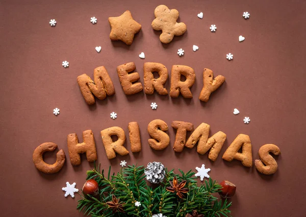 Pão de gengibre palavras Feliz Natal no fundo marrom escuro — Fotografia de Stock