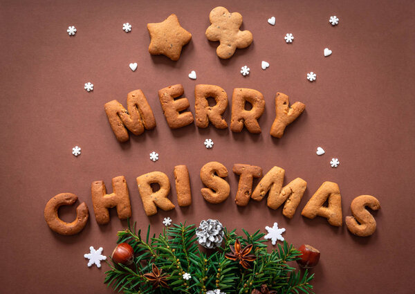 Gingerbread words Merry Christmas on dark brown background