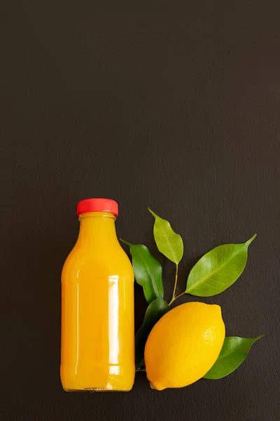 Limoni Freschi Maturi Una Bottiglia Con Succo Fondo Pietra Scura — Foto Stock