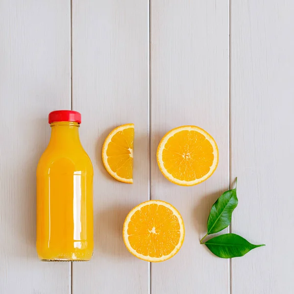 Pomerančový džus v láhvi a čerstvý citrus. Zdravý nápoj — Stock fotografie