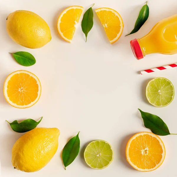En gräns av citrusfrukter på bordet, färskpressad juice i en flaska — Stockfoto