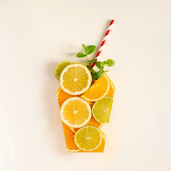 A glass of juice from citrus slices, a sprig of mint and straws for a cocktail on a white background Stock Image