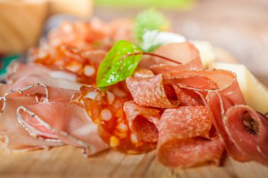 Rustic plate with sausage and ham  clipart