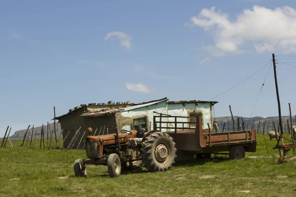 Landelijk dorpshuis met trekker — Stockfoto