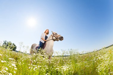 kadın horseriding çiçekli çayırda