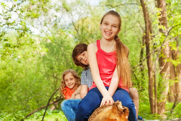 Barnen sitter på Stock i rad — Stockfoto