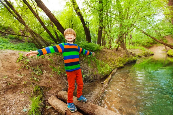 Junge balanciert auf Holzbrücke — Stockfoto