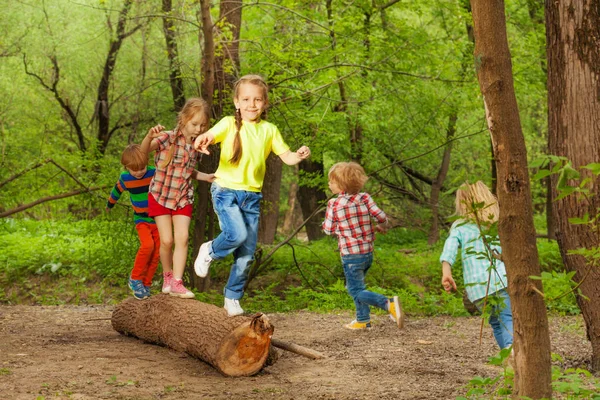 Niños jugando en el registro en el bosque — Foto de Stock