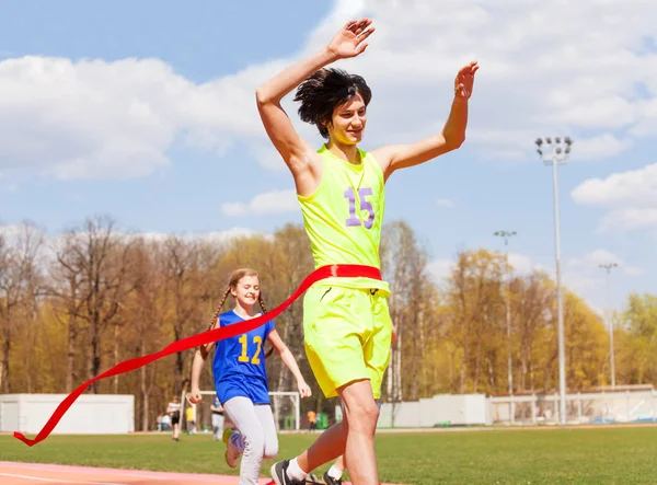 Ganador adolescente cruzando la línea de meta — Foto de Stock