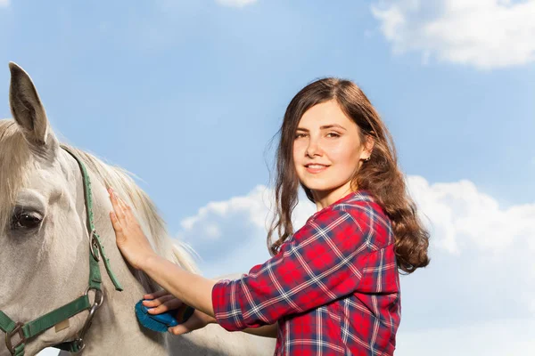Žena kartáčovací krásný kůň — Stock fotografie