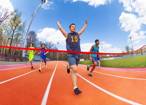 Adolescente sprinter cruzamento linha de chegada — Fotografia de Stock