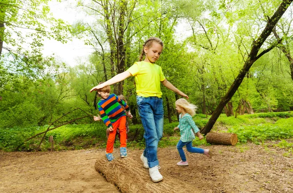 Niños de pie sobre tronco y equilibrio —  Fotos de Stock