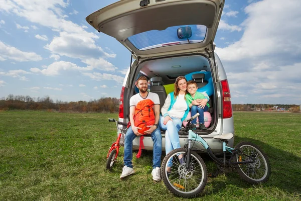 Семья, сидящая в открытом багажнике — стоковое фото